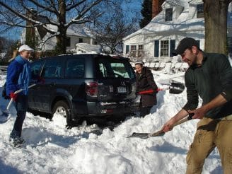 A man shoveling his neighbor's snow