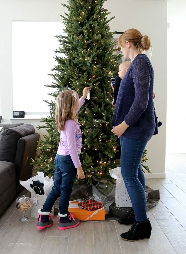 placing Christmas ornaments on the tree