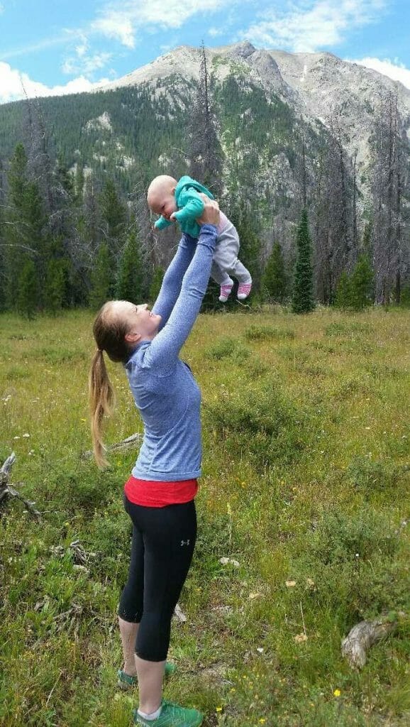 holding baby at mountains