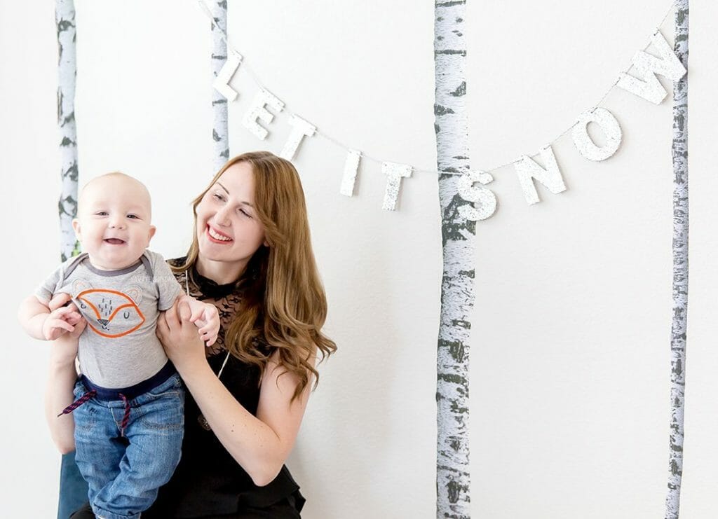 mom and baby under Let It Snow sign