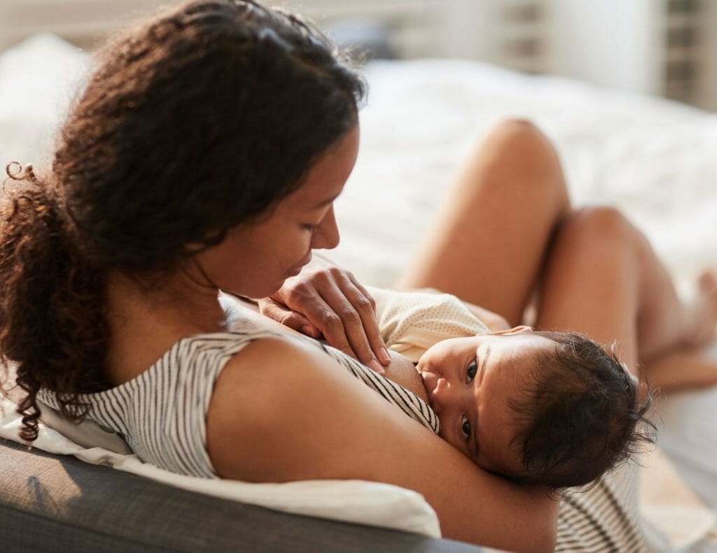 breastfeeding mom holds baby