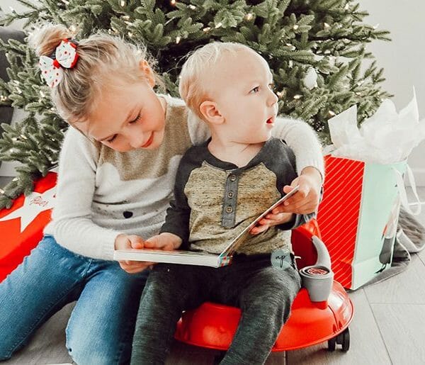 River and S reading a book by the Christmas tree