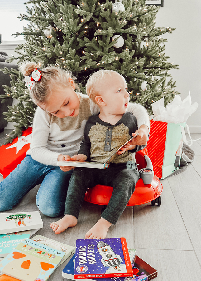 River and S reading a book by the Christmas tree