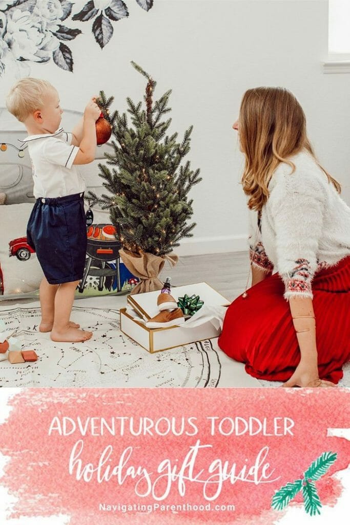 mother and baby sit on ground with toddler by tree
