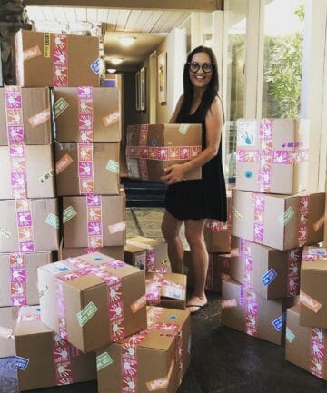 Kim stands with closed summer art boxes