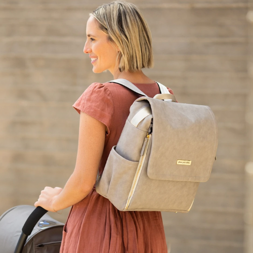 Mom pushes stroller with diaper bag backpack