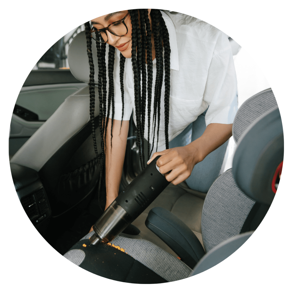 mom cleans car seat with travel vacuum