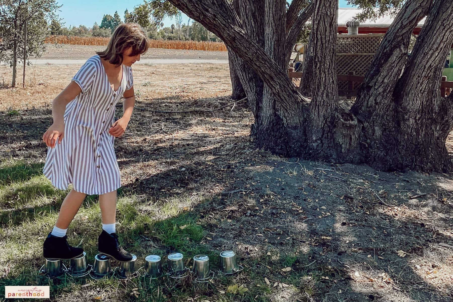 girl trying the balance bucket activity at a Wild West birthday party