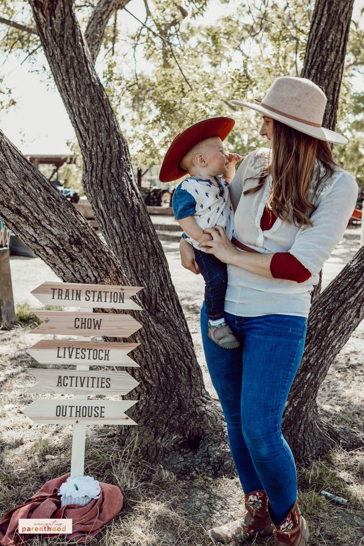 Wild West mom and baby near sign
